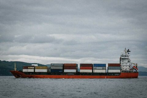 Container ship with containers and a grey sky.