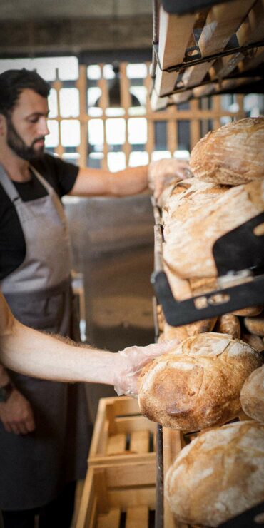 Bakers in a bakery handling bread.