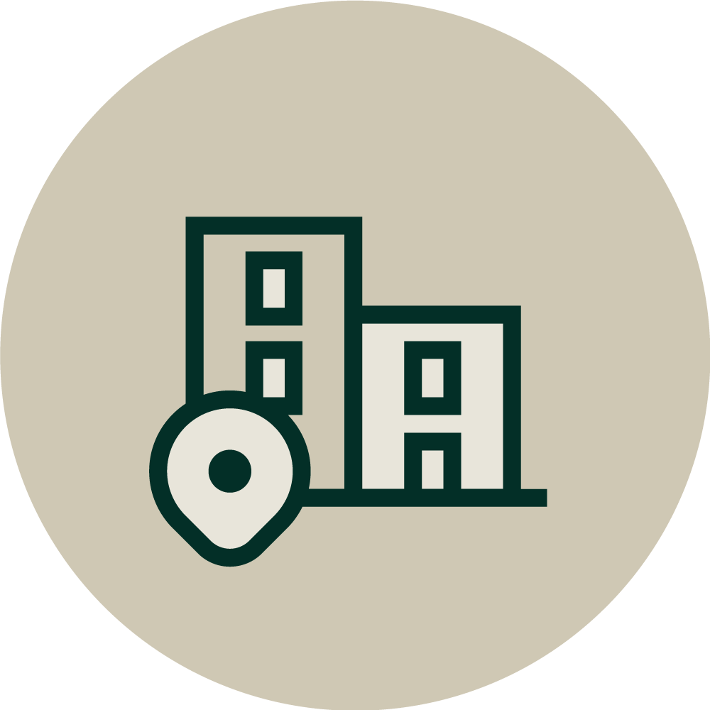 Icon of two simple, outlined buildings with windows overlapping each other, a location pin in front, all within a beige circular background—ideal for representing an Ingredients Distributor.