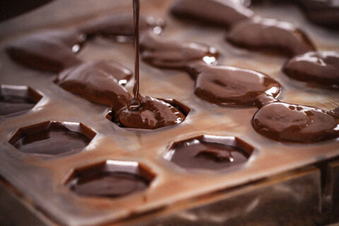 Melted vegan chocolate being poured into a cast.