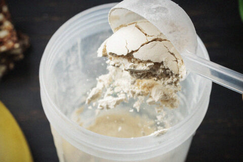 Protein powder being poured into a protein shake.