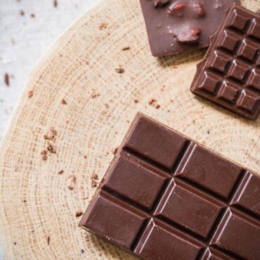 Bars of homemade chocolate on a wooden board.