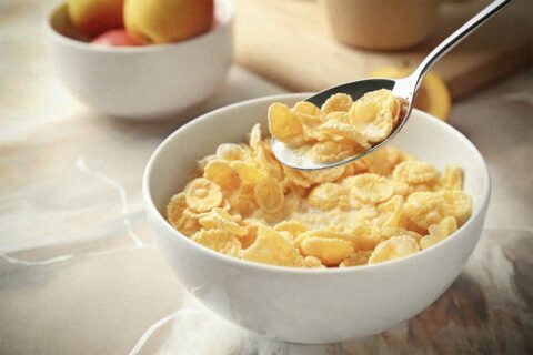 Spoon scooping up cereal from a bowl.