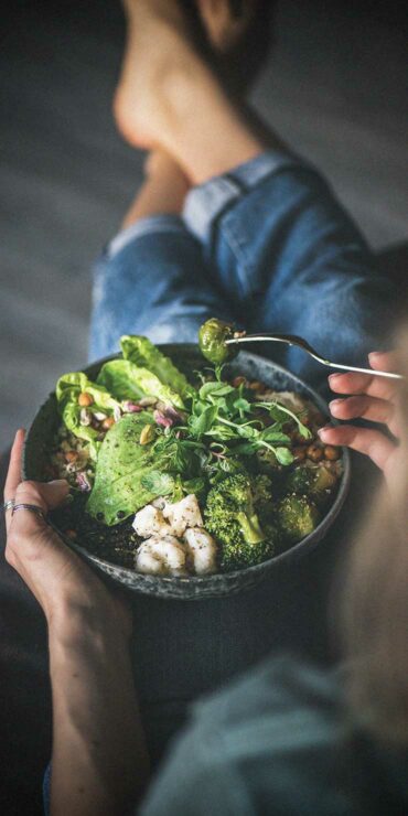 Woman eating healthy salad bowl.