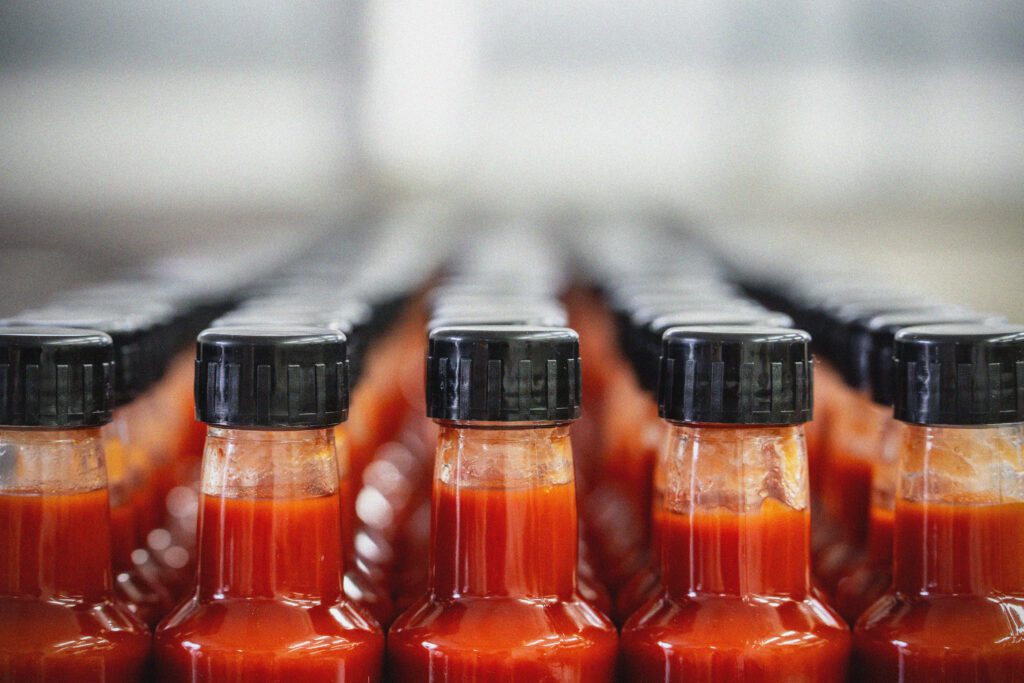Bottles of sauce on a shelf.