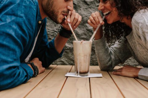 Two people drinking a milkshake.